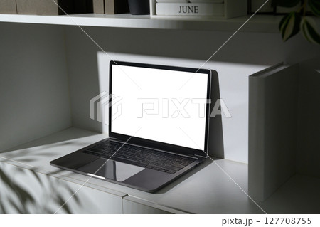 Laptop ready for design display with copy space on screen, framed by neutral tones and light 127708755