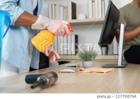 Cleaning and Organization. Two friends tidying up a modern living space with a rainbow flag. 127708794