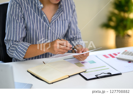 Young entrepreneur checking business data at home workspace 127708882