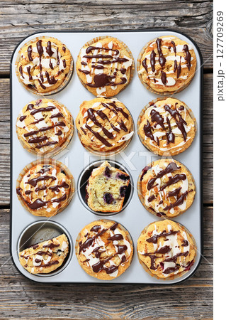 tasty blueberry muffins with lemon chocolate glaze 127709269