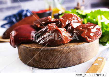 Raw Beef liver meat on wooden board with peppers 127709319