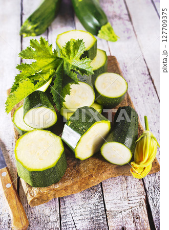 Slicing zucchini on a cutting board. Ripe zucchini. Top view, horizontal. Slicing zucchini on a cutting board. Ripe zucchini. Top view, horizontal. 127709375