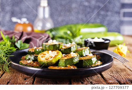 Tasty fried zucchini slices on a plate 127709377