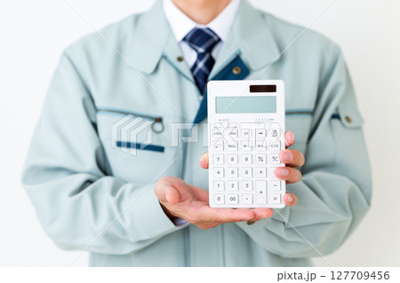 グリーンの作業服を着て電卓を持つミドル男性ビジネスマン 127709456