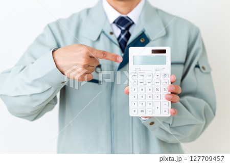 グリーンの作業服を着て電卓を持つミドル男性ビジネスマン 127709457