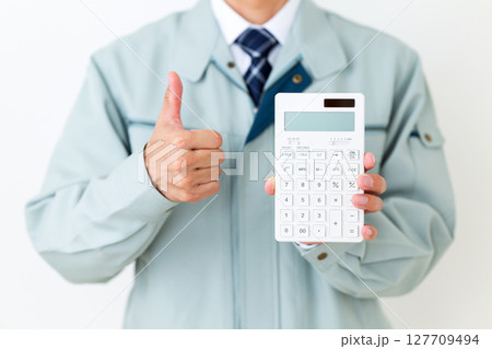 グリーンの作業服を着て電卓を持つミドル男性ビジネスマン 127709494