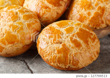 Homemade Chinese pineapple buns freshly baked and fluffy resemble the texture of pineapple close-up. Horizontal 127709513