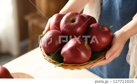 Woman's hands holding a plate with ripe red apples. 127711020