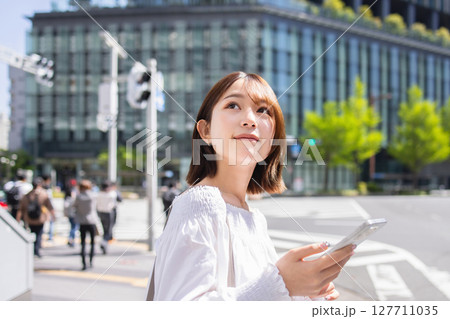 スマホを持つ笑顔の女性 スマホを持つ笑顔の女性 127711035