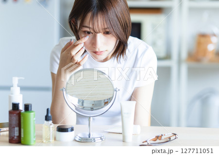 鏡を見てお肌のチェックをする女性 鏡を見てお肌のチェックをする女性 127711051