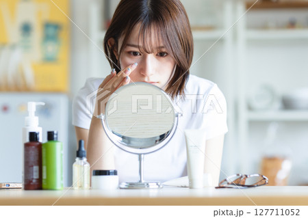 鏡を見てお肌のチェックをする女性 鏡を見てお肌のチェックをする女性 127711052