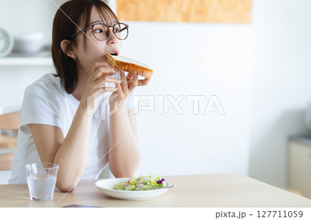 朝食を食べる若い女性 127711059