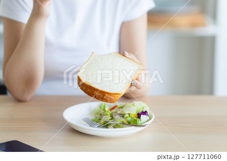 朝食を食べる若い女性 127711060