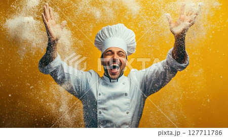 Chef celebrates a successful baking session by tossing flour in the air, showcasing joy in a vibrant kitchen environment with a bright yellow backdrop 127711786