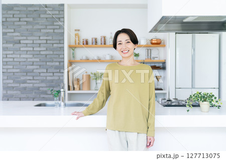キッチンで笑うミドルの女性 127713075