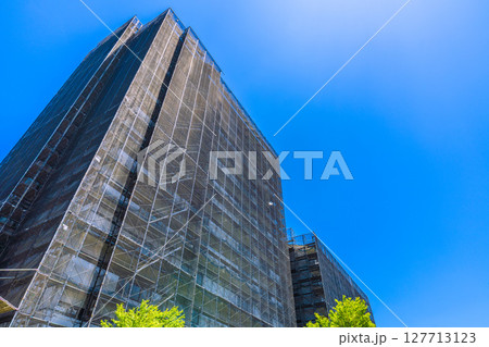 日本の横浜都市景観　マンションの補修や点検等、足場や防護ネットなど。ネットの外に衛星アンテナが… 127713123