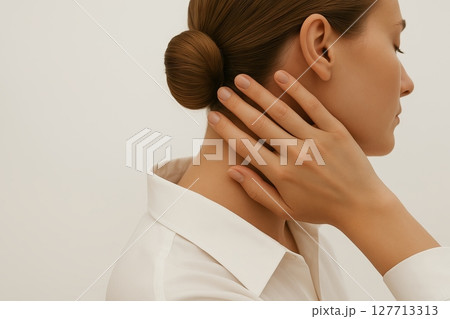 Woman in white shirt holding her neck in side view. Concept of neck pain, muscle tension, physical discomfort, stress-related strain, cervical spine issues, copy space, white background 127713313