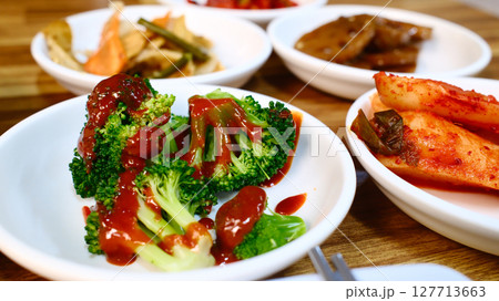 Fresh broccoli with savory brown sauce Korean side dish banchan served on white plate as part of traditional Korean meal 127713663