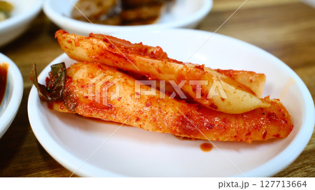 Traditional Korean pickled radish banchan with spicy red pepper seasoning served as classic fermented vegetable side dish 127713664