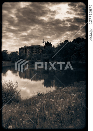 The image captures the silhouettes of buildings against a moody The image captures the silhouettes of buildings against a moody 127713679