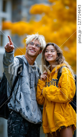 A man and a woman standing next to each other in front of a tree 127714643