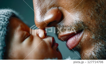 A man kissing a baby's nose on the cheek 127714706
