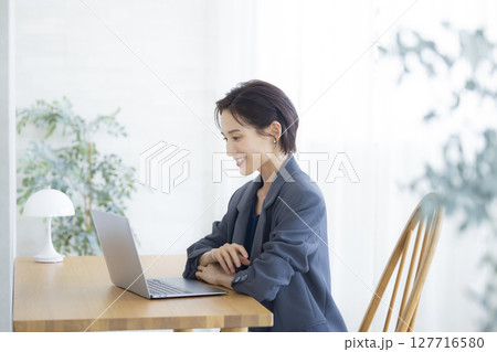 リビングでパソコン作業をする女性 リビングでパソコン作業をする女性 127716580