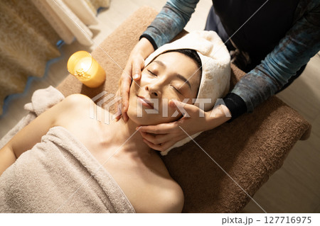 フェイスマッサージの施術を受ける女性 フェイスマッサージの施術を受ける女性 127716975
