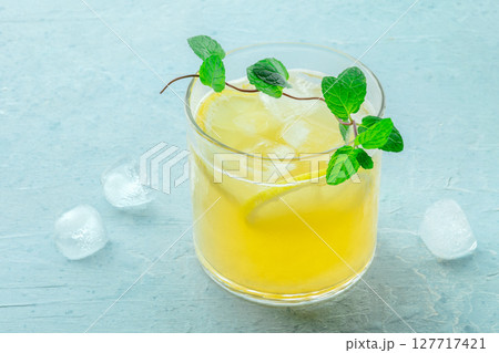 A glass of lemonade, a mocktail with lemon juice, on a blue background 127717421
