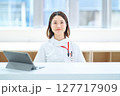 テーブルの前に座る白衣の女性 127717909
