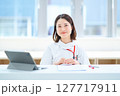 テーブルの前に座る白衣の女性 127717911