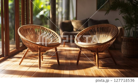 Two wicker chairs sit on a sunlit wooden floor...のイラスト素材 [127718536 ...