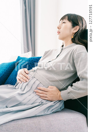 お腹が張って苦しさを感じる妊婦 お腹が張って苦しさを感じる妊婦 127718591