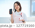 スマートフォンを持つ白衣とエプロン姿の女性 127719160