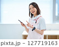 スマートフォンを持つ白衣とエプロン姿の女性 127719163