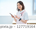 スマートフォンを持つ白衣とエプロン姿の女性 127719164