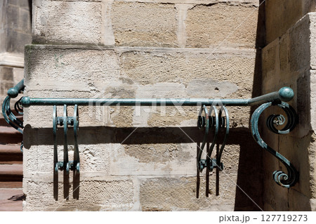 Intricate Ironwork: Decorative Handrail and its Unique Design Feature on Stone Wall Evokes Charm of Historical Architecture and Craftsmanship in Urban Settings 127719273