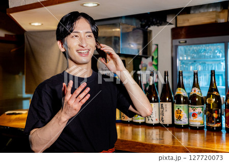 バーでスマホで会話する男性 バーでスマホで会話する男性 127720073