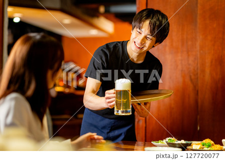 居酒屋で接客をするバイトの男性 居酒屋で接客をするバイトの男性 127720077