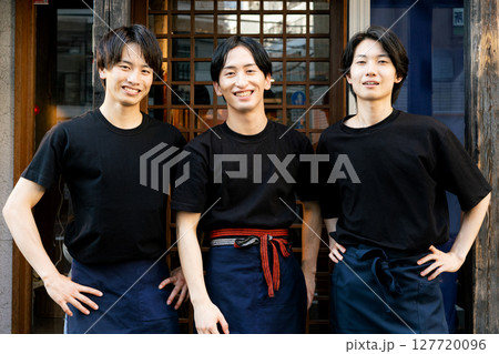 居酒屋の前に立つ男性たち 127720096