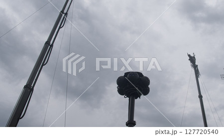 Surveillance equipment stands tall amidst dark clouds, as military forces monitor the area for potential threats during ongoing armed conflict. 127720540