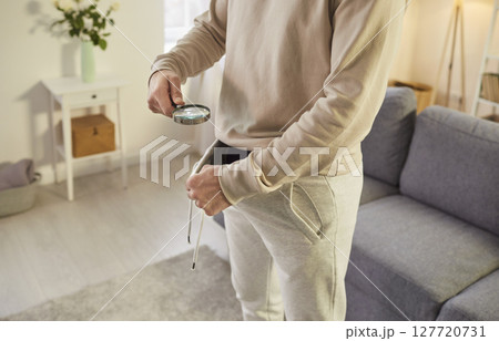 Curious faceless man looking under pants with magnifying glass 127720731