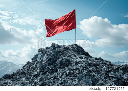 red flag stands tall on rocky mountain peak, symbolizing achievement and leadership 127721955