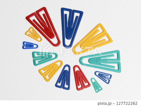 Plastic paper clips in various colors and sizes, isolated on white. 127722262
