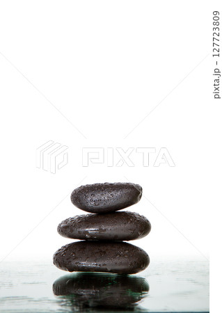 Stack of wet black spa stones isolated 127723809