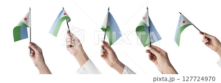 The Djibouti flag in hand in different angles on a white background The Djibouti flag in hand in different angles on a white background 127724970