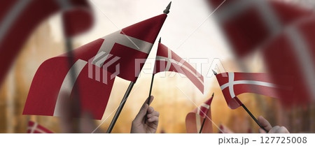 Denmark flags in their hands on a blurred urban background Denmark flags in their hands on a blurred urban background 127725008