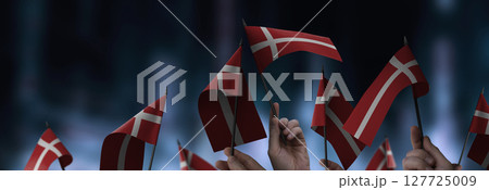 Denmark flags in their hands on a blurred urban background Denmark flags in their hands on a blurred urban background 127725009