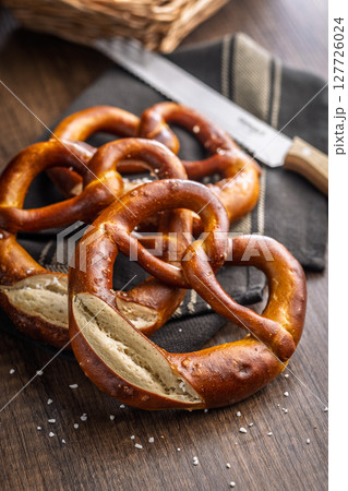 Salted bavarian pretzel on wooden table. Salted bavarian pretzel on wooden table. 127726024