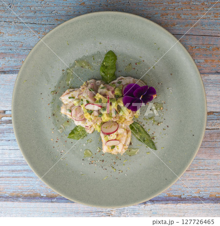 Fresh dorade and shrimp ceviche with avocado, radish, and edible flower on a decorated plate Fresh dorade and shrimp ceviche with avocado, radish, and edible flower on a decorated plate 127726465